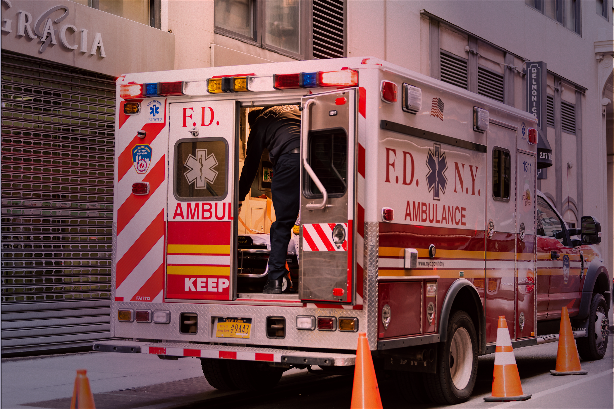 NYC midtown with FDNY red ambulance open truck parked on street